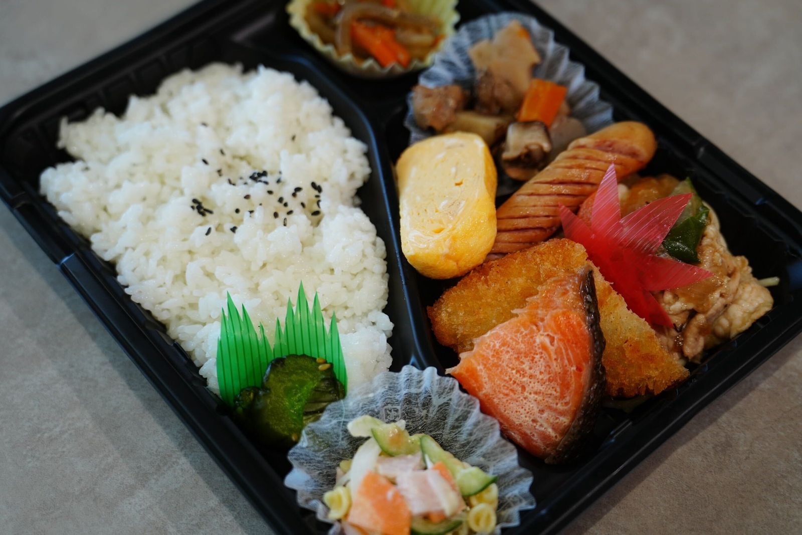幕の内弁当。焼き鮭、玉子焼き、煮物、ウインナー、サラダ